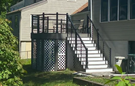 Raised backyard porch with Black VueTube along the stair case and porch. Porch is attached to back of home.