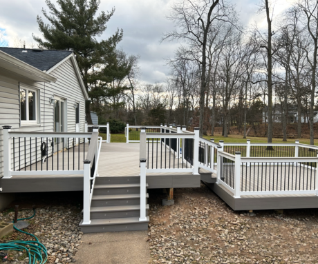 PVC Railings with Black Round Baluster and Top Rail Deck Board Deck Over Railing. The Top Rail matches the deck board used on deck.